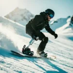 Snowboarder met prothesebeen carvet zelfverzekerd door poedersneeuw op bergpiste in fel winterzonlicht