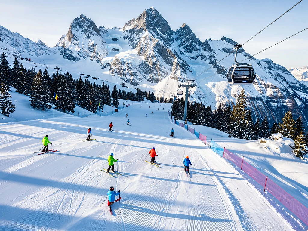 Luchtfoto van skiërs op besneeuwde hellingen in Argentière met Mont Blanc op achtergrond, Franse Alpen