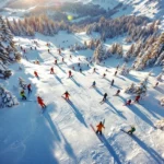 Luchtfoto van Fieberbrunn skipistes in ochtendlicht met skigroepen, instructeurs en Oostenrijkse Alpen op achtergrond