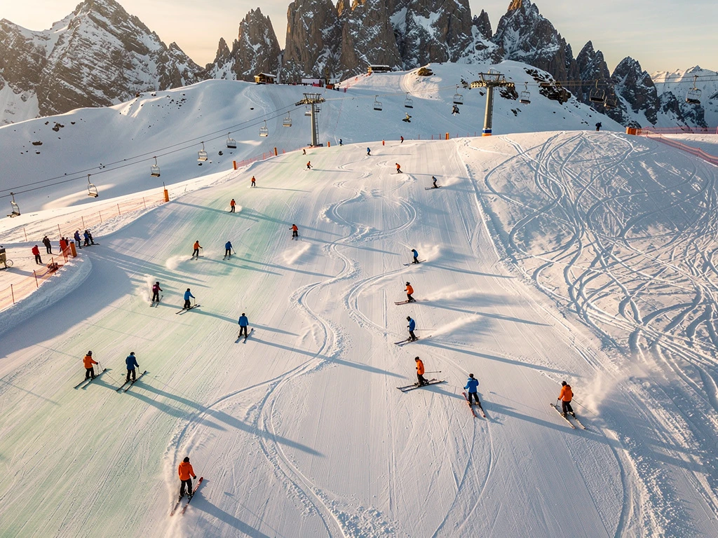 Luchtfoto van Kappl's skipistes met skileraren in oranje jassen die groepen begeleiden op verschillende terrein niveaus