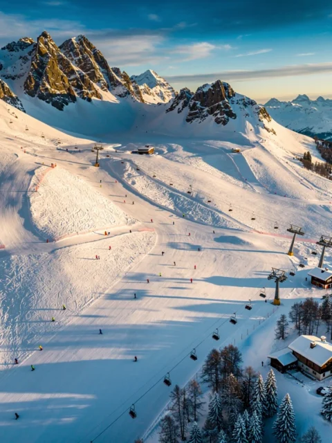 Luchtfoto van Peisey-Vallandry skigebied met besneeuwde pistes, skiërs, liften en Alpine chalets in gouden zonlicht
