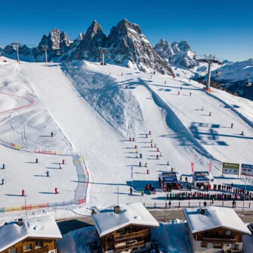 Aerial view of Samoëns ski resort in French Alps with ski instructors teaching groups on snowy slopes under blue skies