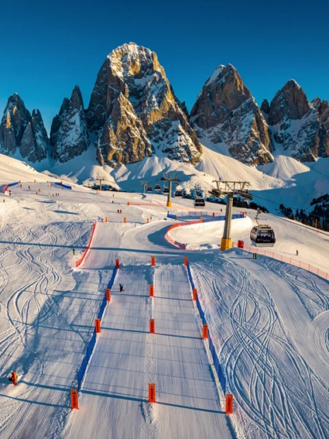 Luchtfoto van skigebied Scheffau am Wilden Kaiser met besneeuwde pistes, gondelbaan en Oostenrijkse Alpen op achtergrond