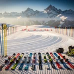 Ski lesson area at La Rosière with groomed powder snow, colorful poles, safety cones, and mountain peaks under blue sky