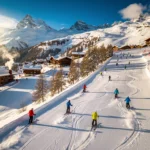 Aerial view of Méribel ski slopes with instructors in bright jackets leading student groups down groomed powder runs in golden sunlight