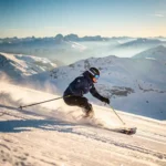 Skiër in marineblauwe jas maakt een perfecte parallelle bocht op een verzorgde Alpenhelling, poedersneeuw spat op in goudkleurig ochtendlicht.