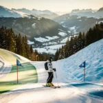 Skiër bij een kruispunt van groene en blauwe piste, met vers poedersneeuw en een Alpien dal omgeven door dennenbossen op de achtergrond.
