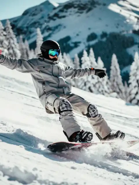 Beginnende snowboarder verliest balans op besneeuwde helling met dennenbomen op achtergrond