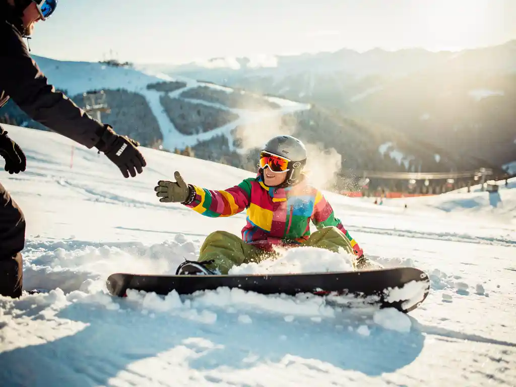 Snowboarder in bunter Winterkleidung nimmt Hilfe vom Skilehrer an, nachdem er im Pulverschnee gestürzt ist