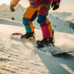 Snowboarder demonstrating proper foot positioning on powder snow during golden hour on mountain slopes