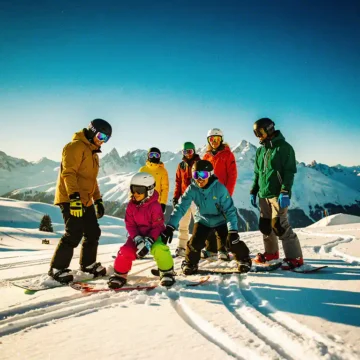 Diverse groep snowboarders van verschillende leeftijden op besneeuwde bergpiste met kleurrijke winterkleding en helmen