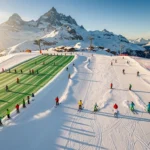 Luchtfoto van skiërs op besneeuwde pistes in Vallorcine met Alpen op achtergrond in gouden ochtendlicht